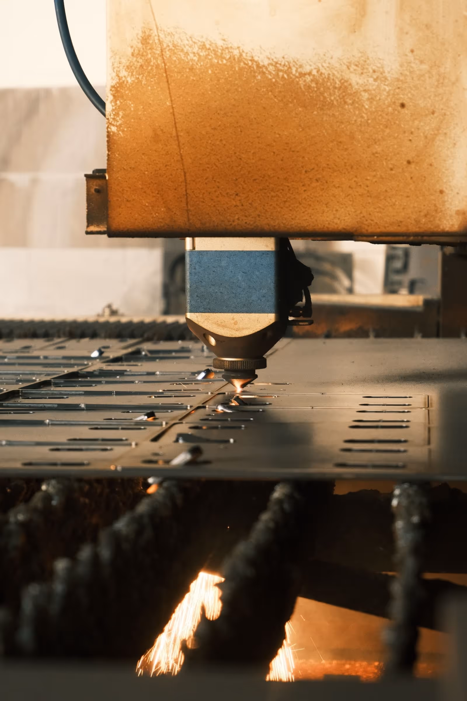 Testa di taglio laser CNC in azione su lamiera d'acciaio con scintille